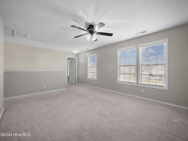 carpeted spare room featuring ceiling fan