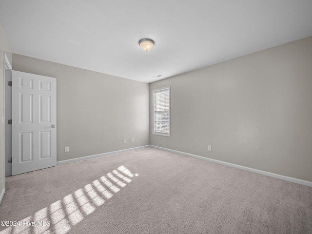 unfurnished room with light carpet