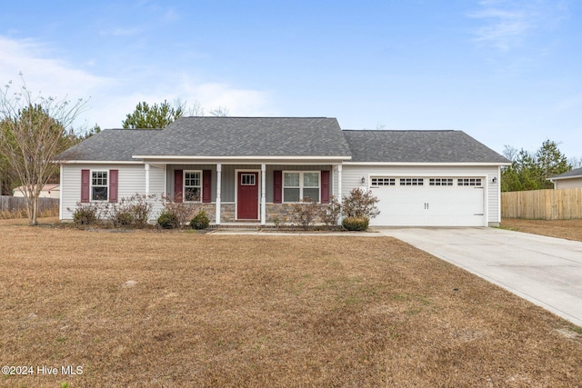 single story home featuring covered porch, a front yard, and a garage