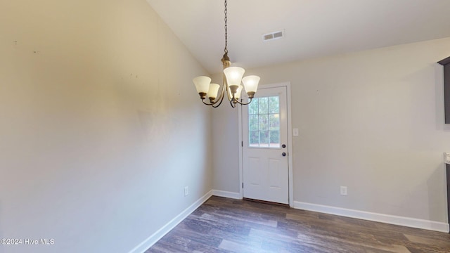 unfurnished dining area with dark hardwood / wood-style floors, an inviting chandelier, and lofted ceiling