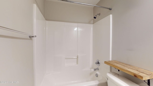 bathroom featuring shower / bathing tub combination and toilet