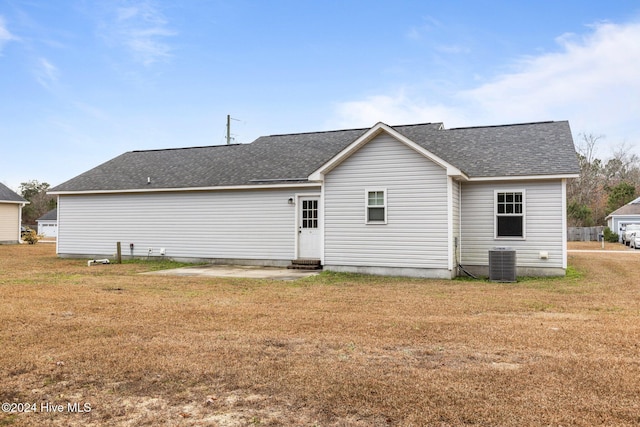 rear view of property with a yard and central AC