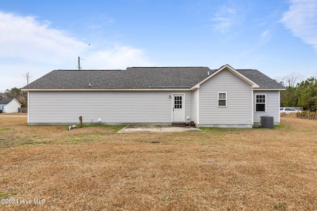 rear view of house featuring cooling unit, a patio area, and a yard