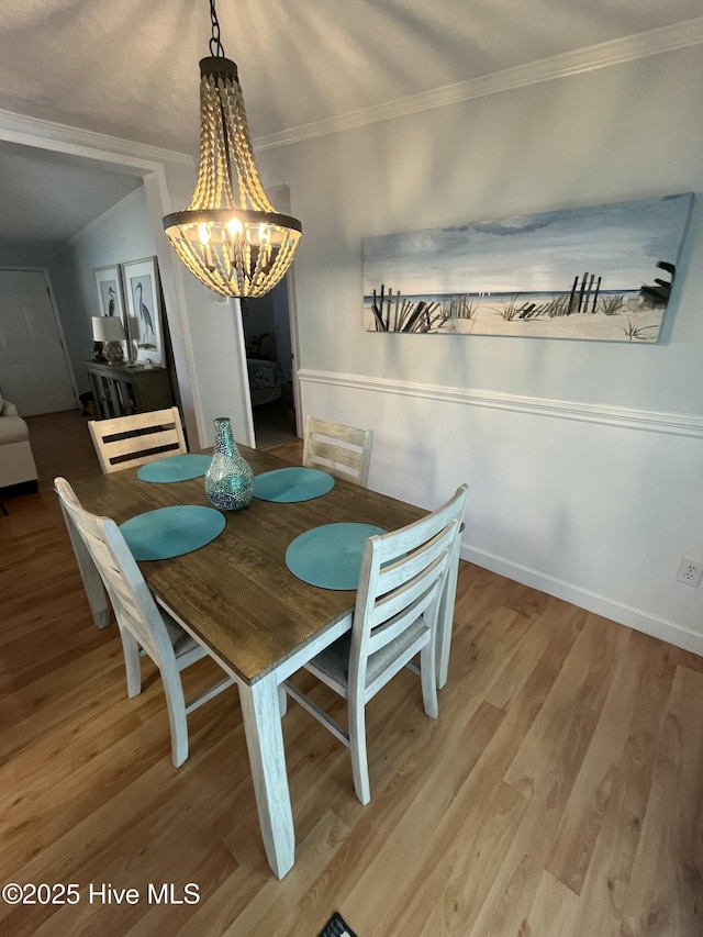 dining room with hardwood / wood-style floors, a notable chandelier, crown molding, and a textured ceiling