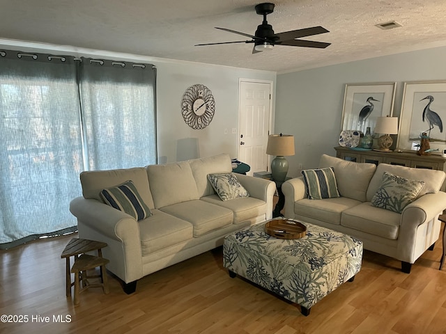 living room featuring a textured ceiling, hardwood / wood-style flooring, and ceiling fan