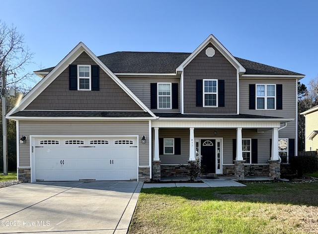 craftsman-style home featuring a front yard, a garage, and covered porch