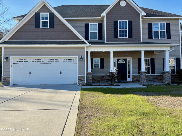 craftsman house with covered porch, a garage, and a front yard