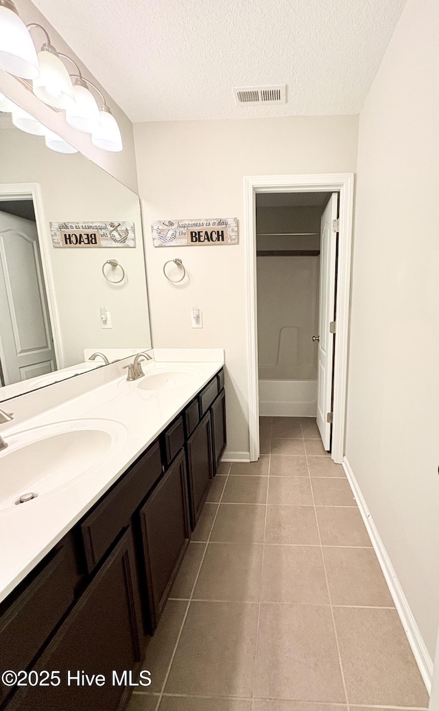 bathroom featuring tile patterned flooring, a textured ceiling, and vanity