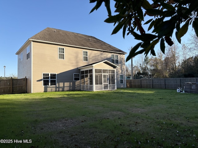 back of house featuring a lawn and a sunroom