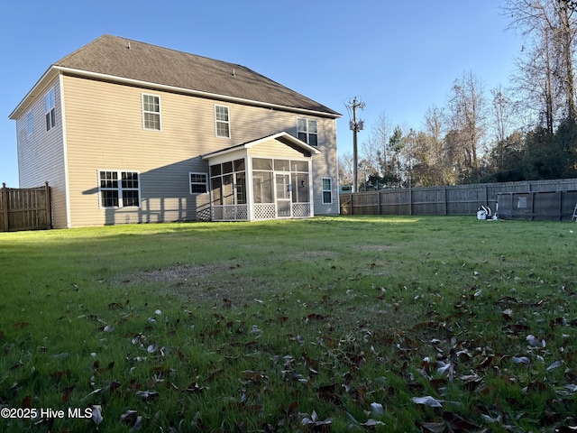 rear view of property featuring a sunroom and a yard