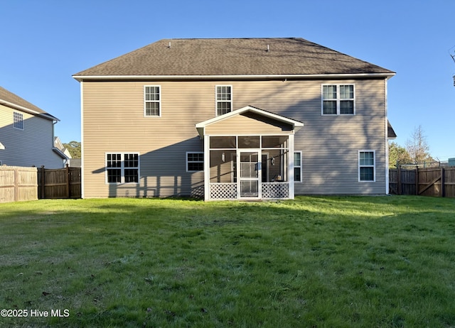 rear view of property with a yard and a sunroom