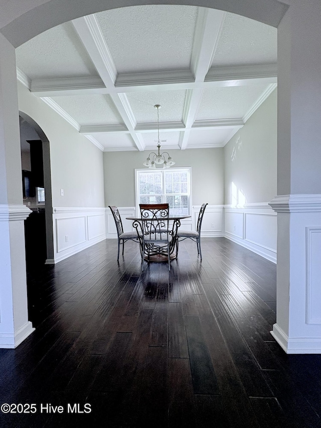 dining area featuring dark hardwood / wood-style flooring, beamed ceiling, coffered ceiling, and ornamental molding