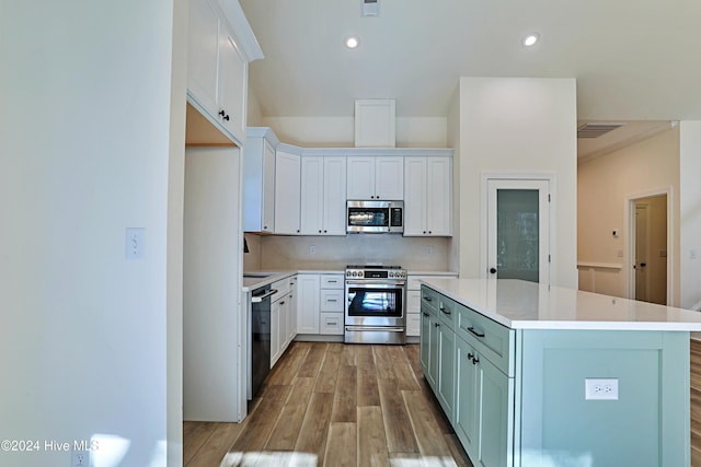 kitchen featuring stainless steel appliances, a kitchen island, visible vents, light countertops, and decorative backsplash