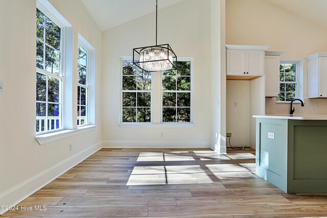 kitchen featuring sink, stainless steel appliances, decorative backsplash, white cabinets, and light wood-type flooring