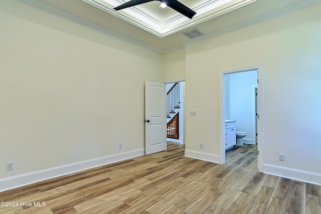 spare room with crown molding, a ceiling fan, light wood-style floors, baseboards, and stairs