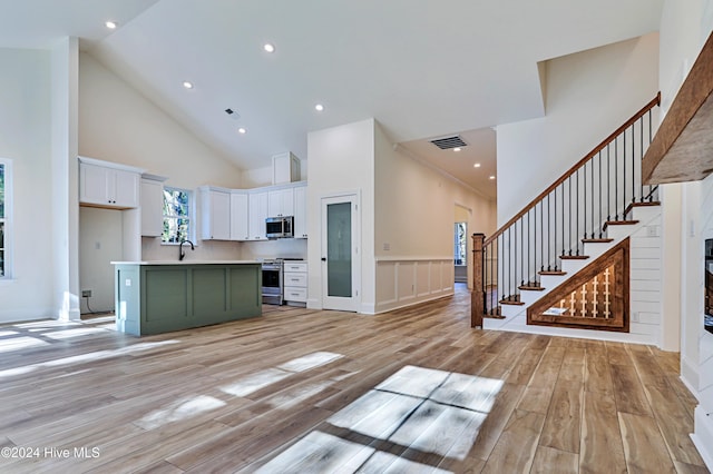 3375 Sandridge Ln SW, Supply, NC 28462 - kitchen with high vaulted ceiling, stainless steel appliances, white cabinetry, visible vents, and a kitchen island