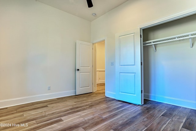 unfurnished bedroom with hardwood / wood-style floors, a closet, and ceiling fan