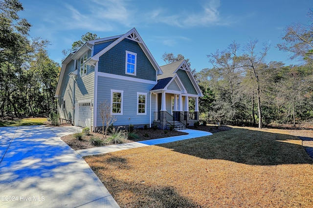 craftsman inspired home featuring driveway, covered porch, a garage, and a front yard