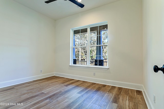 spare room with a ceiling fan, baseboards, and wood finished floors