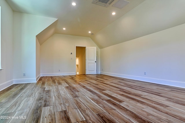 additional living space with visible vents, baseboards, lofted ceiling, wood finished floors, and recessed lighting