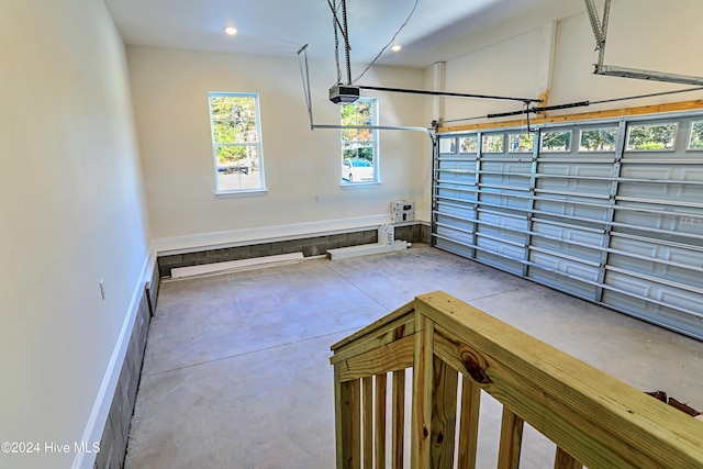 garage featuring a garage door opener and baseboards