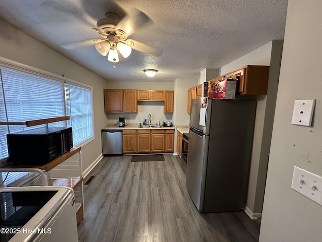 kitchen featuring hardwood / wood-style floors, sink, ceiling fan, a textured ceiling, and appliances with stainless steel finishes