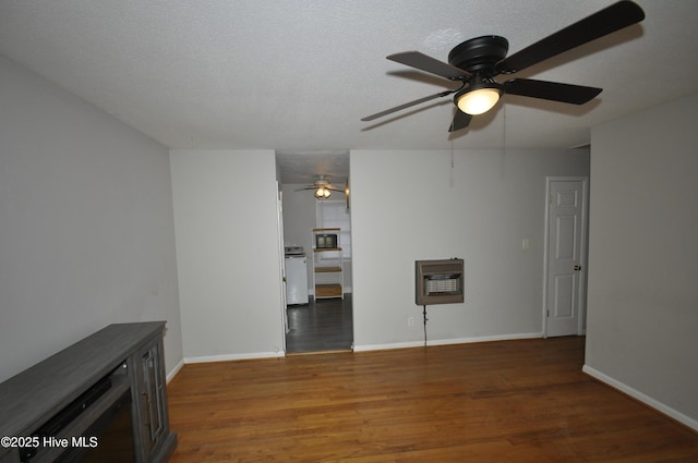 unfurnished living room featuring dark hardwood / wood-style floors, ceiling fan, a textured ceiling, and heating unit