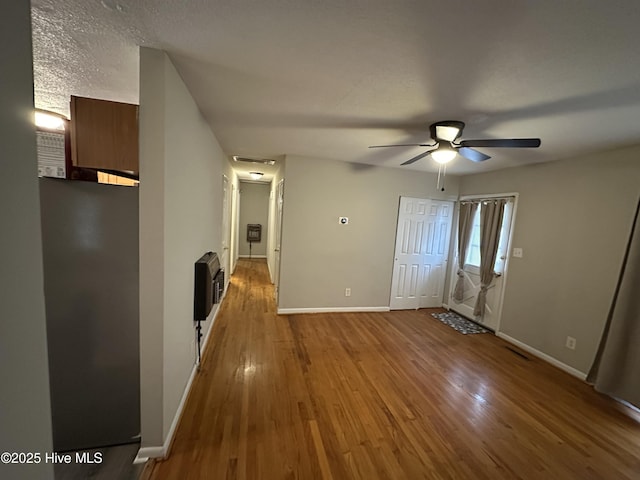 interior space with heating unit, a textured ceiling, and hardwood / wood-style flooring