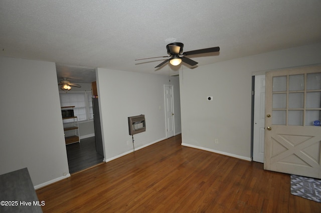 unfurnished living room with a tiled fireplace, ceiling fan, dark hardwood / wood-style flooring, and a textured ceiling