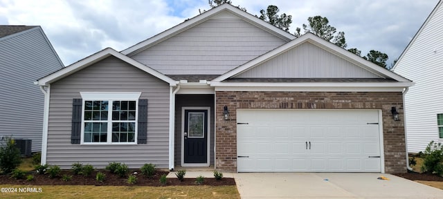 craftsman house with central air condition unit and a garage