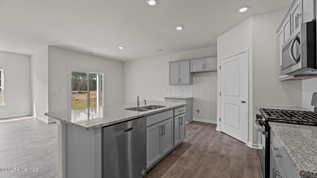 kitchen with sink, white cabinets, light hardwood / wood-style flooring, and appliances with stainless steel finishes