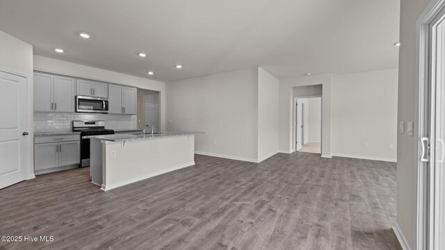 kitchen featuring white cabinets, dark stone countertops, light hardwood / wood-style flooring, and tasteful backsplash