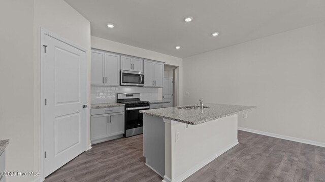 kitchen featuring white cabinetry, appliances with stainless steel finishes, and dark stone counters