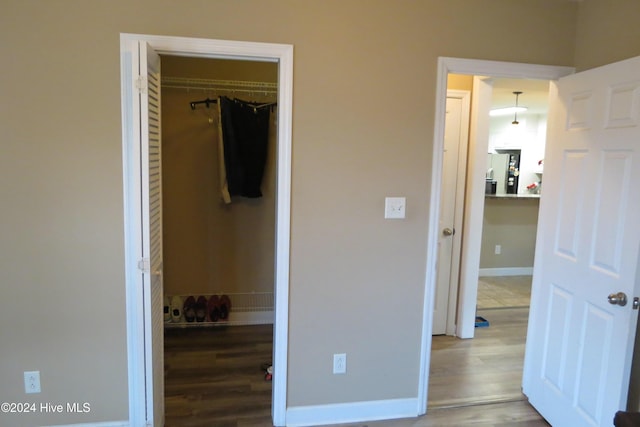 bedroom with a closet, refrigerator, and hardwood / wood-style floors