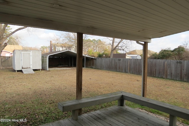 view of yard featuring a wooden deck and a storage shed