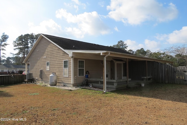 rear view of house with a lawn and central air condition unit