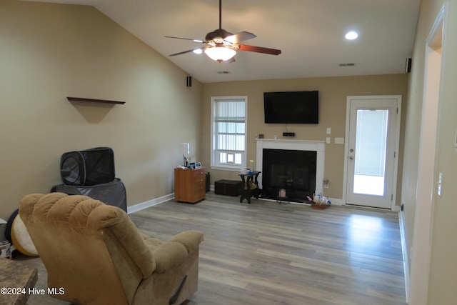 living room with ceiling fan, light hardwood / wood-style floors, and lofted ceiling