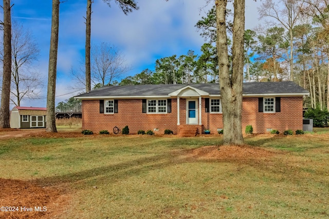 ranch-style house with a front yard and a storage shed