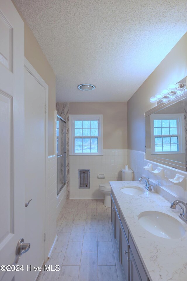 empty room featuring a chandelier, light hardwood / wood-style floors, ornamental molding, and wood walls