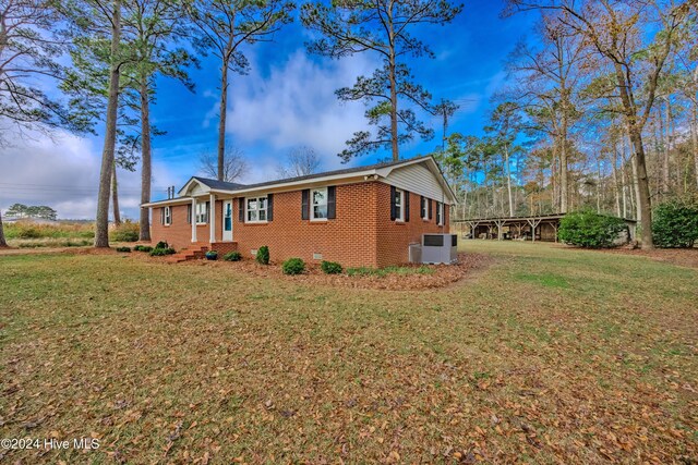 view of side of property with a lawn and cooling unit