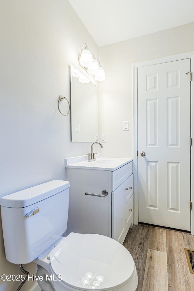 bathroom featuring hardwood / wood-style floors, vanity, and toilet