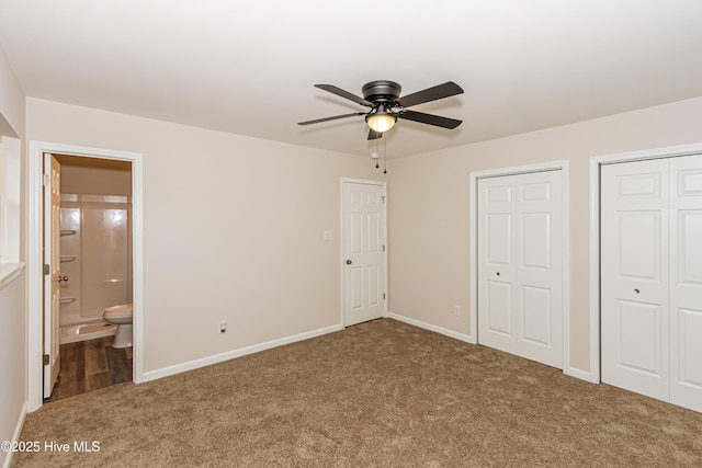 unfurnished bedroom with carpet flooring, connected bathroom, two closets, and ceiling fan