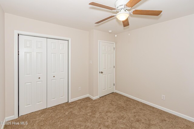 unfurnished bedroom with ceiling fan, light colored carpet, and a closet