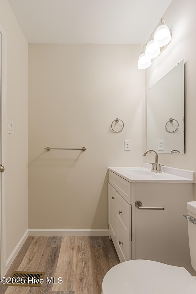 bathroom with vanity, wood-type flooring, and toilet