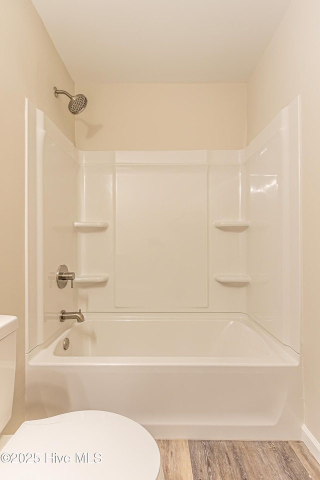 bathroom with shower / bath combination, hardwood / wood-style flooring, and toilet