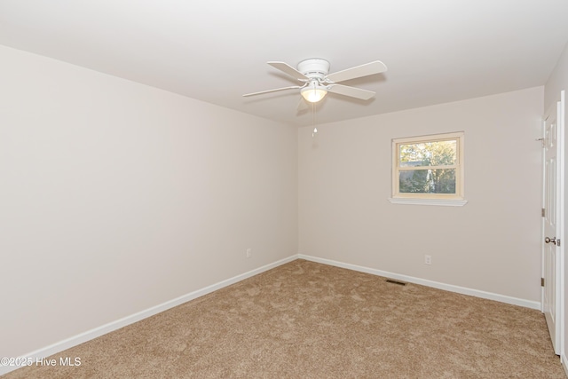 carpeted spare room featuring ceiling fan