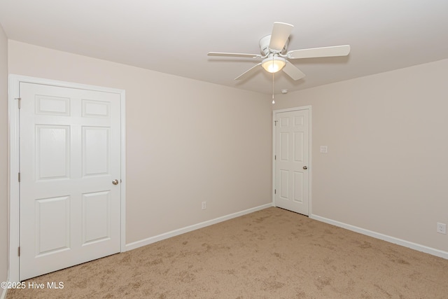 carpeted spare room with ceiling fan