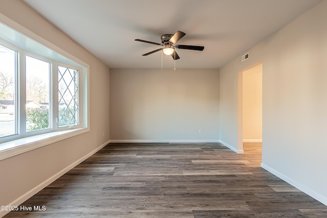 empty room with dark hardwood / wood-style flooring and ceiling fan