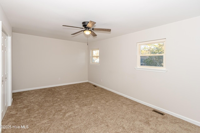 empty room featuring carpet flooring, ceiling fan, and plenty of natural light