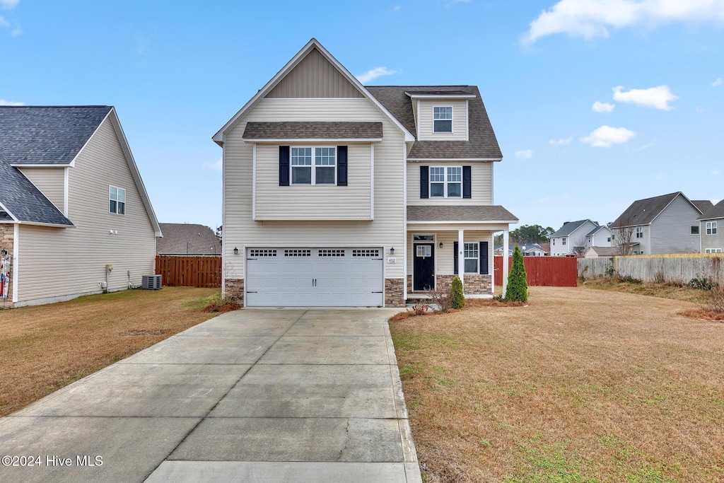 view of front of home with a front yard, a garage, and covered porch